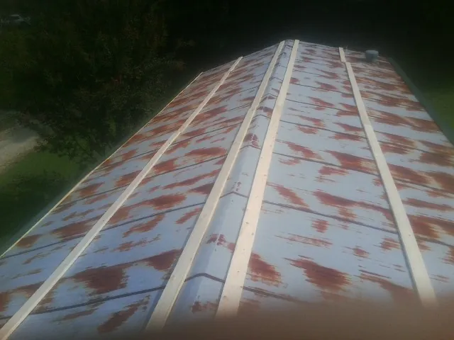 Rusted metal roof panels with new wood purlins before replacement — Storm Damage Roof Repair in Simonton by Roofing Brothers