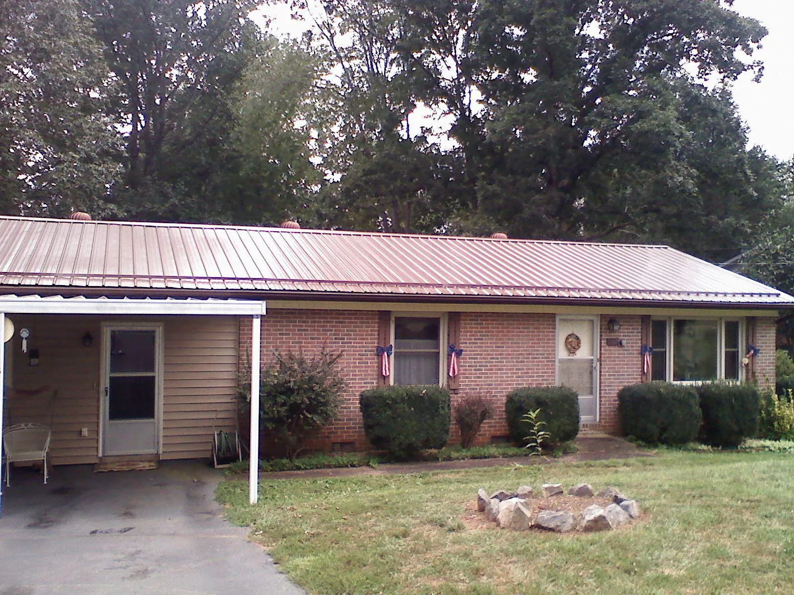 Bronze metal roof and carport on a brick ranch home — Roof Repair work by our crew in Simonton